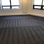 This is a photo of a grey office carpet that has just been professionally steam cleaned works carried out by Haggerston Carpet Cleaning