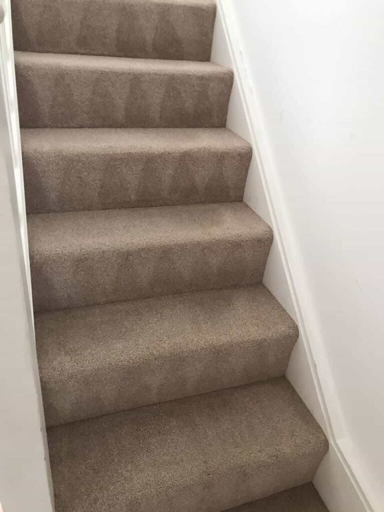 This is an after photo of a staircase with a beige carpet that has been cleaned works carried out by Haggerston Carpet Cleaning