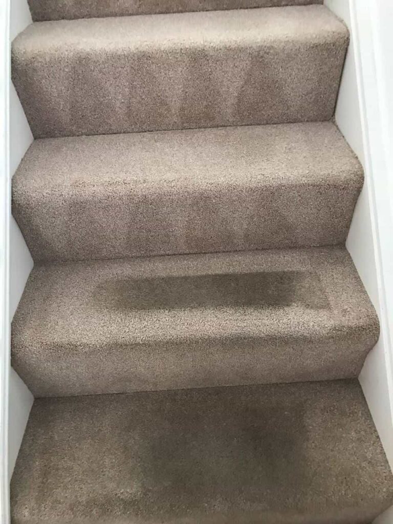 this is a photo of a staircase with beige carpets that is in the process of being cleaned works carried out by Haggerston Carpet Cleaning