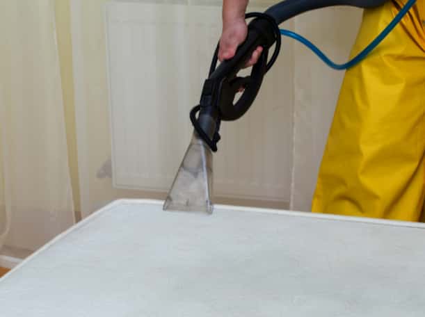 This is a photo of a man steam cleaning a dirty mattress Haggerston Carpet Cleaning